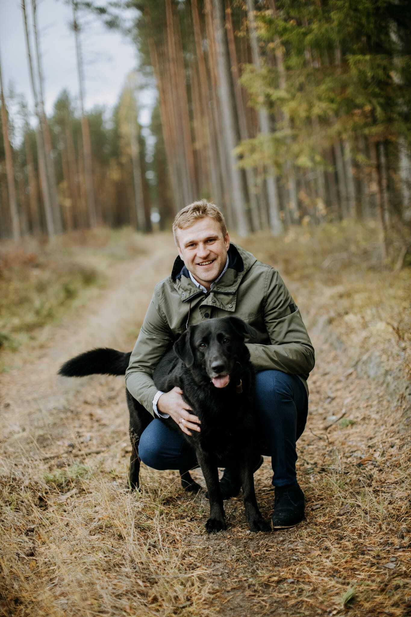 Toms Jansons landowner in the forest with a black dog